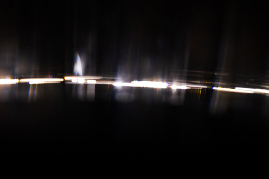 Lens Flare. Light over black background. Easy to add overlay or screen filter over photos. Abstract sun burst with digital lens flare background. Gleams rounded and hexagonal shapes.