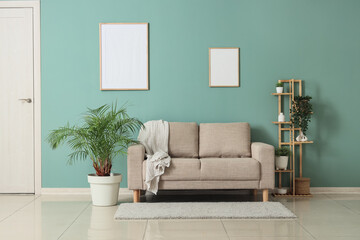 Comfortable sofa, shelving unit and houseplants in interior of living room