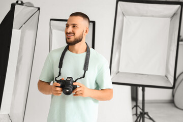 Handsome photographer with camera during courses in studio