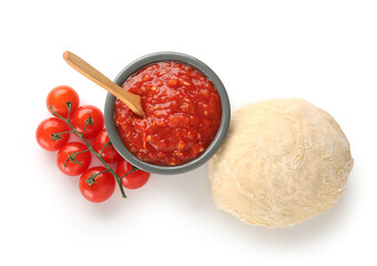 Bowl of tasty sauce with tomatoes and raw dough on white background