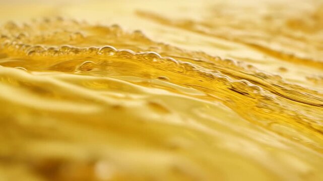 Rippling dark amber liquid surface warming under right-side light at tabletop tank, with bubbles
