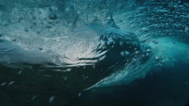 Beginner woman surfer rides the ocean wave in the Maldives. In water and underwater view of the surfer on the wave