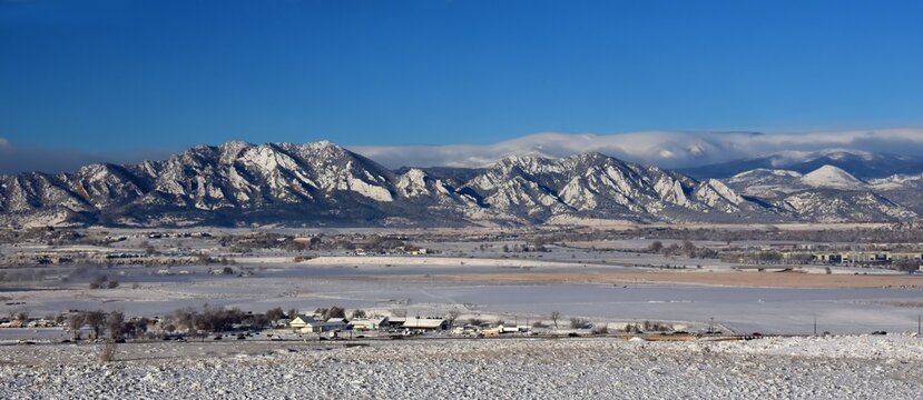 the  striking boulder flatirons and  snow -capped peaks of the front range of the colorado rocky mountains in winter as seen from broomfield, colorado, in early morning