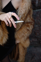 Woman holds her hand with a cigarette
