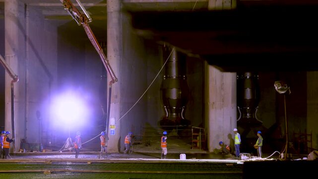 Night Construction Work at Industrial Facility with Large Storage Tanks