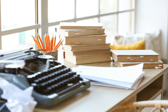 Vintage typewriter with script, books and crumpled paper on desk in screenwriter's office