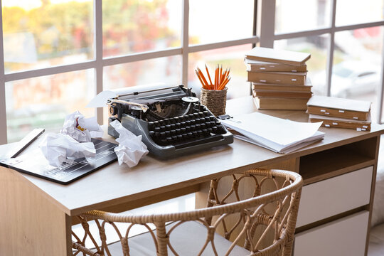Vintage typewriter with script, movie clapper and crumpled paper on desk in screenwriter's office