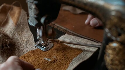 Lowering presser foot, hands guiding needle and mending orange patch on bench beside sewing machine