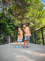Obraz premium Playing with siblings in the park taking photos on a bridge
