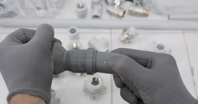 Technician pushes rubber gasket onto plastic fitting seating ring in groove. Technician inserts grey coupling into pipe socket and aligns stop mark checking snug fit