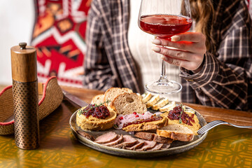 Restaurant appetizer plate with wine in hand