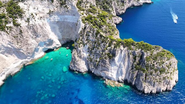 Aerial drone cinematic video of paradise sea caves of Keri with white cliffs and spectacular landscape creating a blue lagoon a true tourist attraction for yachts and boats, Zakinthos, Ionian, Greece