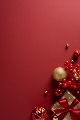 Obraz premium A vertical rich red holiday scene with glittering ornaments, gold accents, a wrapped gift and red berry clusters. Ideal for Christmas and New Year greetings
