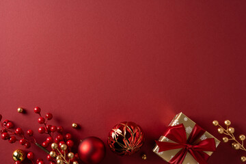 Elegant vertical red gifts wrapped with satin ribbons and gold accents sit beside glass ornaments...