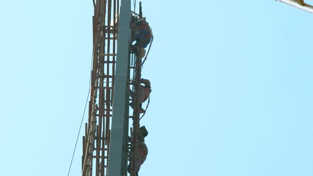 Workers Climbing Large Steel Engineering Structure During Construction