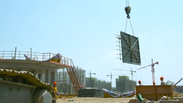 Large Metal Formwork Panel Lifted by Crane at Construction Site