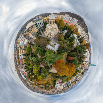 Aerial view of the Sioni Cathedral nestled among vibrant autumn trees and historic buildings under a swirling sky, Tbilisi, Tbilisi, Georgia.