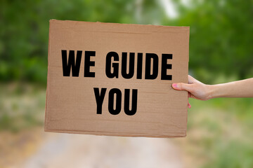 We Guide You message written on ripped torn paper background. Conceptual We Guide You symbol. Copy...