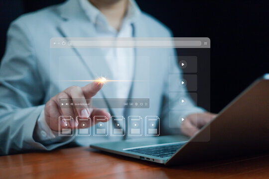 A business professional interacting with a digital interface while using a laptop, highlighting concepts of online media, data management, video streaming, cloud technology, modern digital workflow.
