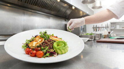 Chef's Hand Garnishing Healthy Gourmet Salad with Grilled Halloumi and Avocado in a Professional Commercial Kitchen
