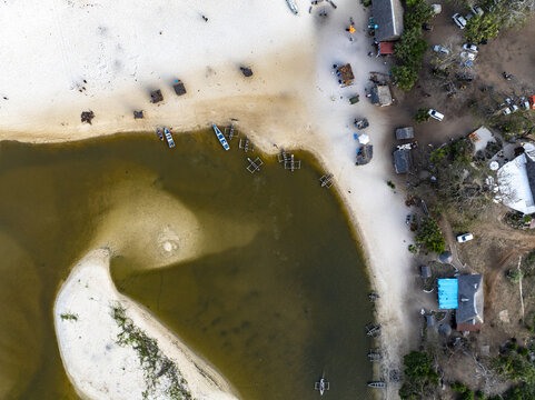 Aerial view of boats resting in the tranquil waters where the river meets the shore, contrasting sharply with the sandy beach, Diani, Kwale County, Kenya.