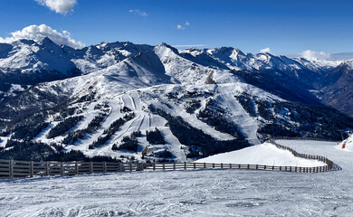 A panoramic view on snow capped Alps in Austria, seen from Katschberg Ski Resort in Austria.The slopes are covered with fresh, powder snow. Idyllic winter landscape. Sunny day