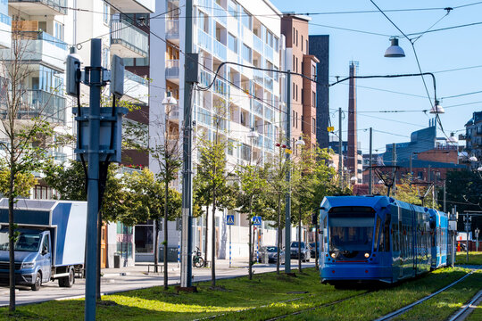 Tram moving through modern infrastructure with greenery in Stockholm Sweden, demonstrating urban mobility, sustainable transport and the reliability of the city network public transit system