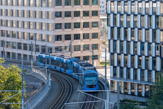 Stockholm Sweden tram curving through modern infrastructure, illustrating urban mobility and transport working together within a connected city network for smooth public transit