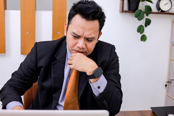Pensive Businessman Ponders Challenges at His Desk in His Modern Office