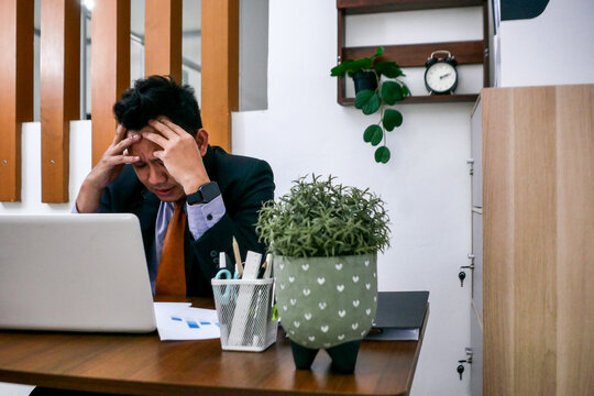 Frustrated Businessman Facing Project Deadline in Modern Office Setting