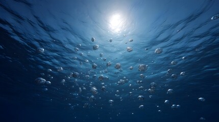 Obraz premium Underwater view of numerous bubbles rising towards the sun s rays penetrating the ocean surface