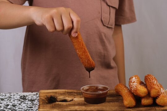 A churro dripping chocolate, creating a delicious and visually appealing food-focused closeup scene.