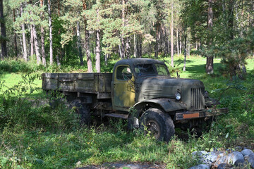 An old abandoned Soviet truck stands in a forest