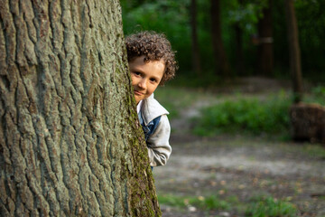 Inquisitive boy exploring something in public park. Park setting and boy wonder are perfect for themes of adventure and exploration. High quality photo.