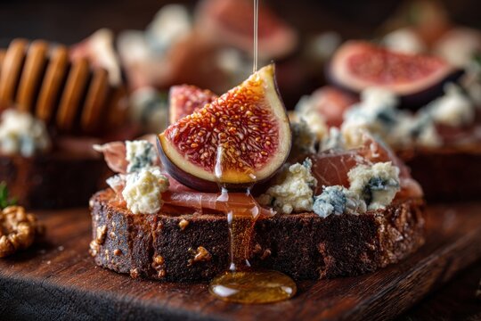 Close-up of dark bread bruschetta topped with caramelized figs, prosciutto, and blue cheese, drizzle of honey - Powered by Adobe