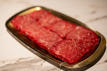 Raw Sliced Hanwoo Beef, marbled Korean Style Meat prepared on the golden plate