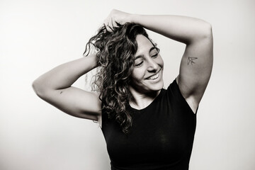 Fototapeta premium Happy woman with curly hair smiling in black and white