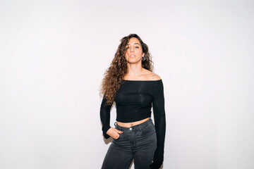 Young woman confidently posing with curly hair and black top