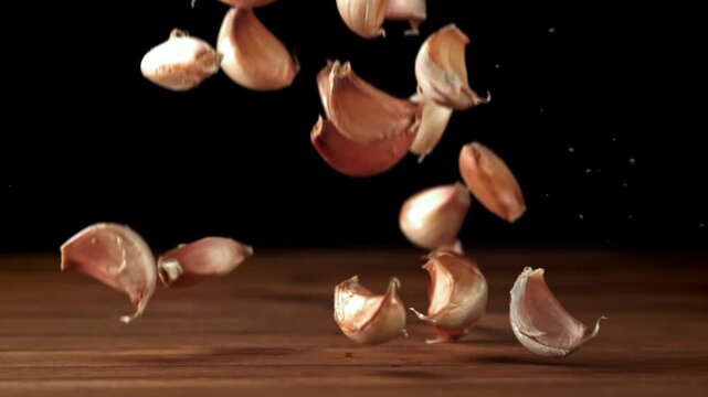 Garlic falls on a wooden table. Filmed on a high-speed camera at 1000 fps. High quality FullHD footage