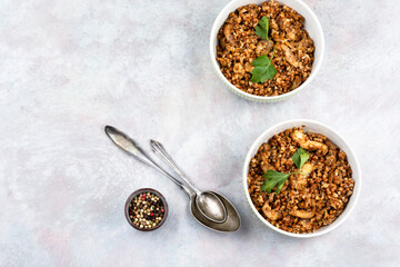 Bowl with cooked buckwheat with pieces of meat.