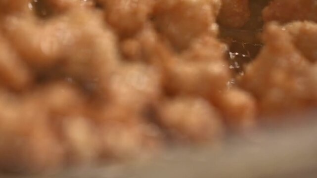 Closeup shot of deep frying chicken pieces in oil.