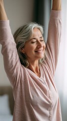 Fototapeta premium Close up of a happy, beautiful elderly woman stretching her arms up. Mature female feeling energetic and relaxed. Morning wellness for senior people.