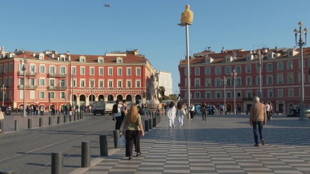 4K French Riviera Nice upward tilt towards plane crossing the sky above place Massena with seagulls flying slow motion