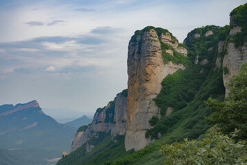 Majestic towering rock cliffs covered in lush green foliage against a cloudy sky in a vast mountain landscape