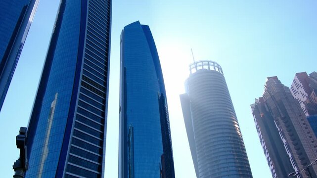Bright daylight reveals Etihad Towers rising over Abu Dhabi, clean lines reflecting sun, modern silhouette shaping strong city mood, clear sky framing powerful architecture in calm summer air.