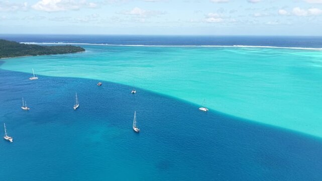 French Polynesia, Drone Shot of Sailboats in Magnificent Lagoon, Coral Reef Barrier Around Island