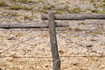 detail of an old wooden fence with rusted barbed wire of a farm,