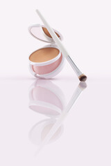 Opened compact powder, blusher with makeup brushes on Glossy Surface