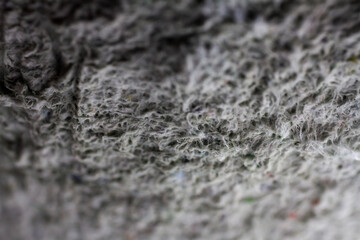 Extreme close up of old gray handmade paper clay with a structure and rough texture. Paper recycling. Selective soft focus, shallow depth of field.