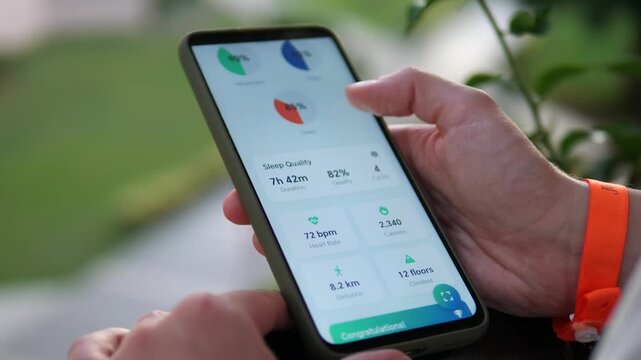 A person engages in mindful health tracking outdoors, analyzing key biometric data collected by her wearable or phone. This clip highlights the integration of technology into daily health management